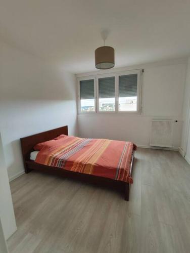 a bedroom with a bed in a white room at Grand F4 avec belle vue in Saint-Étienne