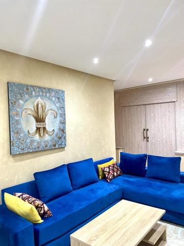 a blue couch in a living room with a table at Cosy appartment Agdal Rabat center in Rabat