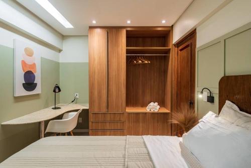 a bedroom with a bed and a desk and a table at 1403 - Flat Excelente em São Luís in São Luís