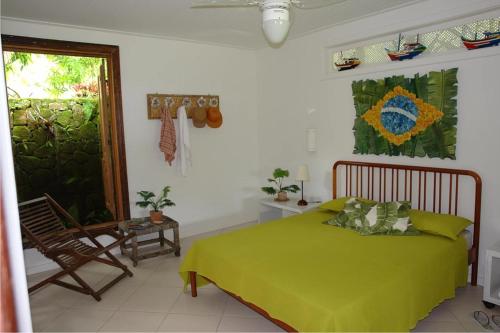 um quarto com uma cama verde e uma cadeira em Angra dos Reis Praia Vermelha em Angra dos Reis