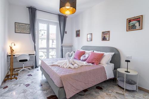 BandeNereSuite Attico في ميلانو: غرفة نوم مع سرير كبير مع وسائد وردية