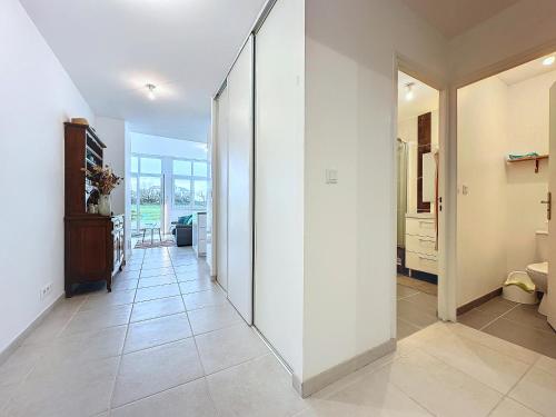 un couloir aux murs blancs et un grand miroir dans l'établissement Le Semaphore T2 proche mer, terrasse, balcon, à Landéda