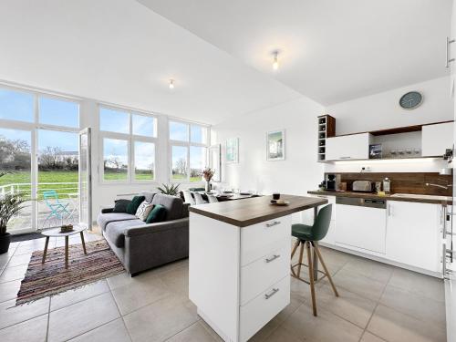 une cuisine et un salon avec un canapé et une table dans l'établissement Le Semaphore T2 proche mer, terrasse, balcon, à Landéda