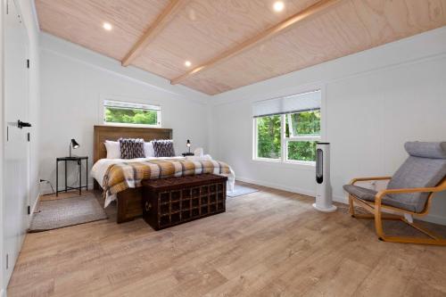 ein Schlafzimmer mit einem Bett, einem Sofa und Fenstern in der Unterkunft Raglan Country Lodge in Raglan