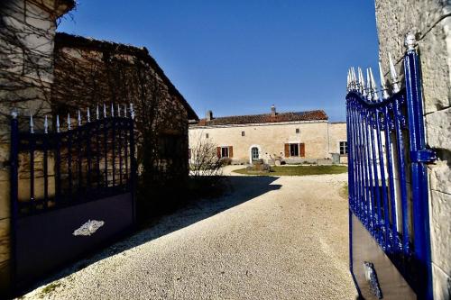 una entrada a un edificio con una puerta azul en Spacious & Characterful 6 Bed Farmhouse with Pool en Vanzay