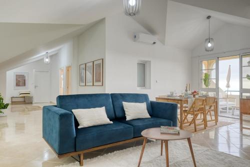 ein Wohnzimmer mit einem blauen Sofa und einem Tisch in der Unterkunft Por do Sol, a Home in Madeira in Ponta do Sol