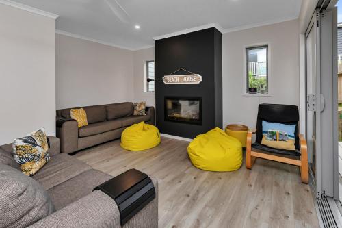 a living room with a couch and a fire place at Seaside Escape - Ruakaka Holiday Home in Ruakaka