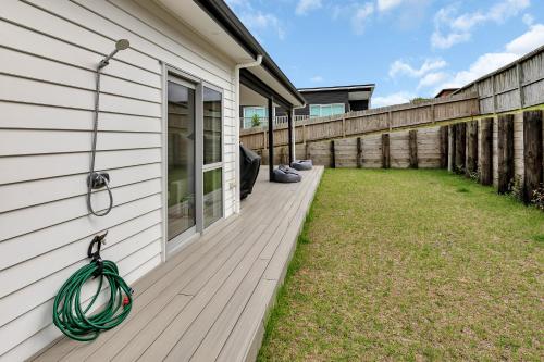a deck with a hose on the side of a house at Seaside Escape - Ruakaka Holiday Home in Ruakaka