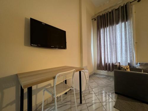 a living room with a table and a television on the wall at Casablanca Central Suites - Casa Port in Casablanca