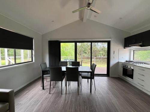 a kitchen and dining room with a table and chairs at Denman Van Village in Denman