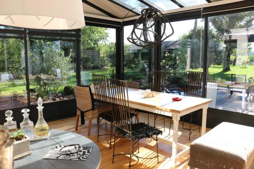 a dining room with a table and some windows at Patis De Cahot au 108 in Bruz