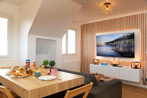 a dining room with a table and a couch at Le CinéRêve l 20' Paris l Netflix l Fibre l Parking in Boissy-Saint-Léger