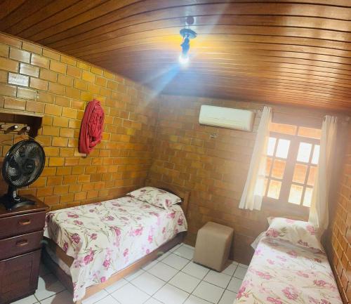 a bedroom with two twin beds and a light at Casa de Campo em Gravatá super aconhegante in Gravatá