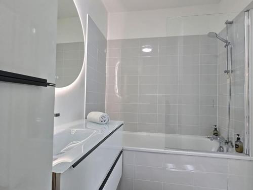 ein weißes Badezimmer mit Badewanne und Waschbecken in der Unterkunft Le Bonheur Charmant *Disney*Paris*RER A* in Bussy-Saint-Georges