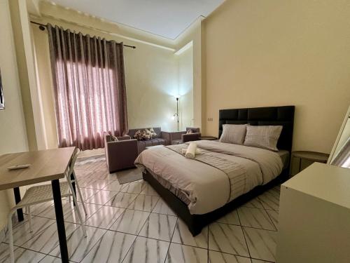 um quarto com uma cama e uma sala de estar com uma mesa em Casablanca Central Suites - Casa Port em Casablanca