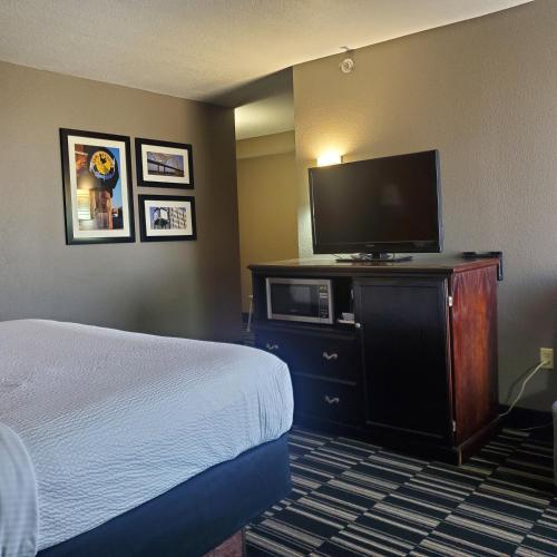 a hotel room with a bed and a flat screen tv at La Quinta by Wyndham Memphis Airport Graceland in Memphis