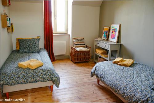 a small room with two beds and a window at Gîte ty nina rosa in Penmarcʼh