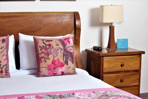 a bedroom with a bed with a pillow and a nightstand at Amazilia Hotel in Pereira