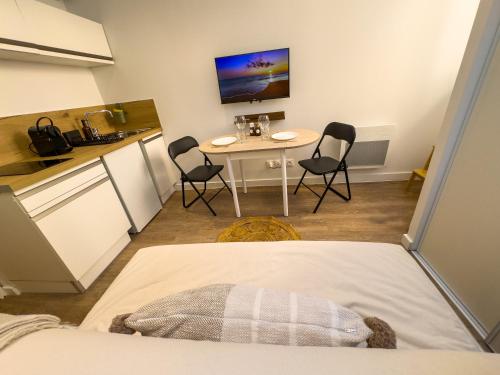 une pièce avec une table et des chaises et une cuisine dans l'établissement Le petit Jean - Studio hyper centre, à Grenoble