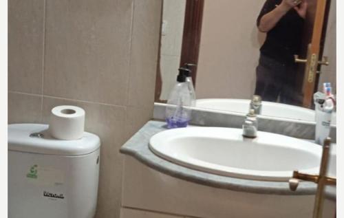 a person taking a picture of a bathroom with a sink at Mark in Tarragona