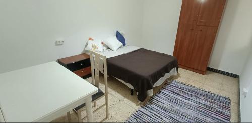 ein kleines Schlafzimmer mit einem Bett und einem Schreibtisch in der Unterkunft Mark in Tarragona