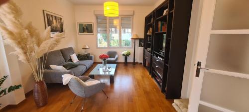 un salon avec un canapé et une télévision dans l'établissement Maison Familiale, à Sceaux