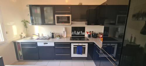 une cuisine avec des placards bleus et un comptoir blanc dans l'établissement Maison Familiale, à Sceaux