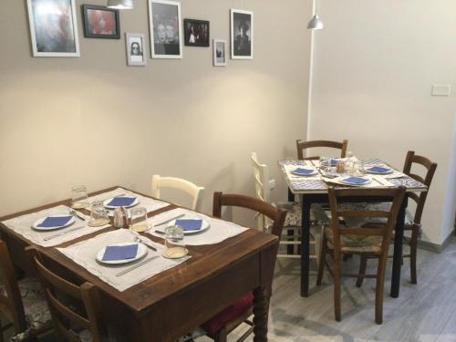 a dining room with two tables and chairs and pictures on the wall at La Casa di Zoe al borgo in Perugia
