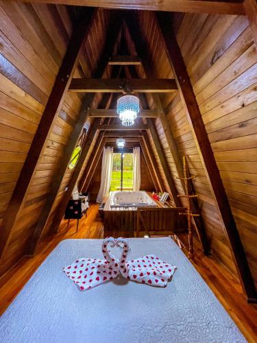 a room with a bed with a bow tie on it at Morada do Corujão - Aconchego in Praia Grande