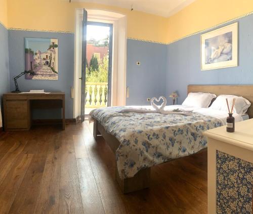 a bedroom with a bed and a table and a window at Apartma Casa della Pizza - Parking included in Izola