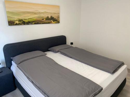 a bed in a bedroom with a picture on the wall at NES 1 - nähe Freiheitshalle Hof in Hof