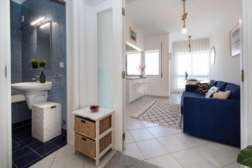 sala de estar con sofá azul y baño en One of the Best Views Costa Nova II, en Costa Nova