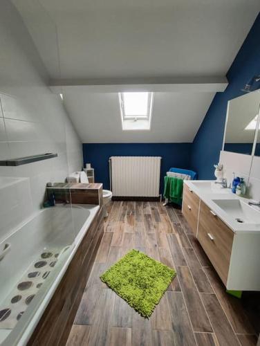 une salle de bain avec une baignoire, un lavabo et un miroir dans l'établissement Maison 240+65m2, piscine, spa, sauna, salle sport, à Saint-Rambert-sur-Loire