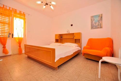 una camera con letto e sedia arancione di Apartments Antonio a Duće