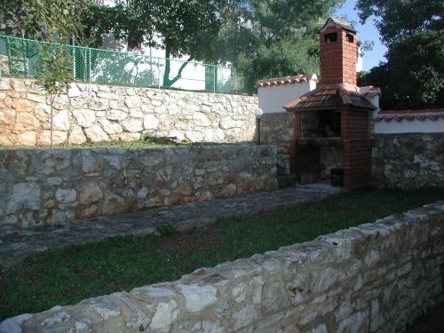 a stone wall with a brick fireplace in a yard at Adriatic View in Pješčana Uvala 
