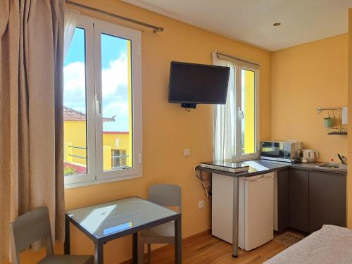a room with a table and a kitchen with a window at Calheta Countryside in Calheta