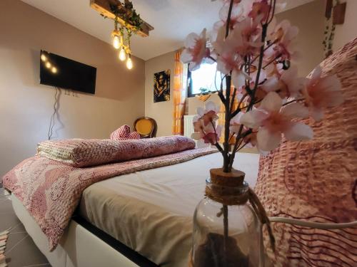 a bedroom with a bed with a vase with flowers in it at Lovely Oasis in Schmelz