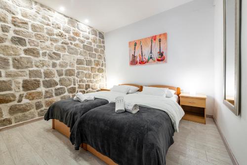 um quarto com 2 camas e uma parede de pedra em Welcome Apartment - Old Town em Dubrovnik