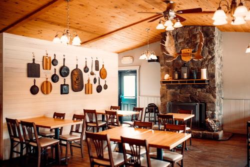 a restaurant with wooden tables and chairs and a fireplace at Denali Cabins in McKinley Park
