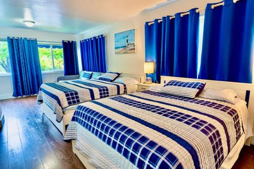 twee bedden in een kamer met blauwe gordijnen bij Casa Wynwood Miami in Miami