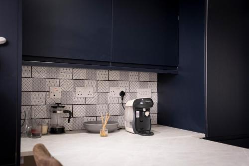 a kitchen with black cabinets and a counter top at Luxurious London Studios in Harrow