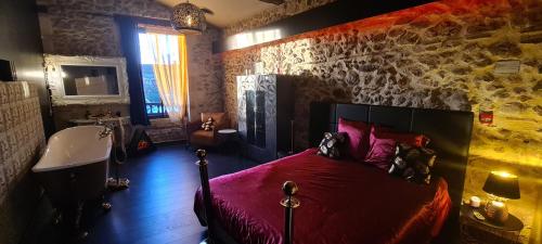 1 dormitorio con cama roja y lavamanos en CHEZ PAM agréable chambre d’hôte pour les amoureux en Marmande