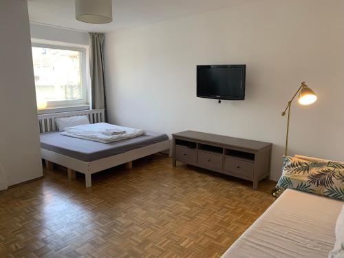 a room with two beds and a tv on the wall at Studio Flat Medien Hafen 30minToFair in Düsseldorf