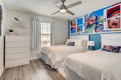 1 Schlafzimmer mit 2 Betten und einem Deckenventilator in der Unterkunft 4808 LL Magical 4BR Disney Townhome Pool in Kissimmee