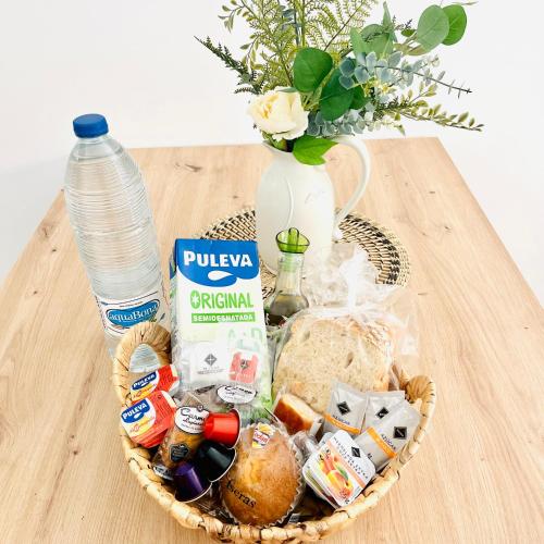 een mand met eten en een fles water op een tafel bij Picú Home in Málaga