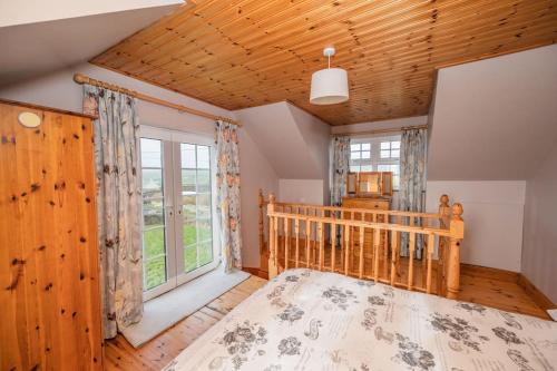 a bedroom with a crib and a large window at Mullally House Liscannor (Wild Atlantic Way) in Liscannor