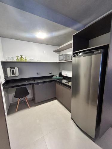 una pequeña cocina con nevera de acero inoxidable. en Studio 905, en Marília