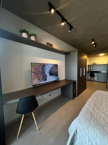 sypialnia z łóżkiem i telewizorem na ścianie w obiekcie Studio 905 w mieście Marília