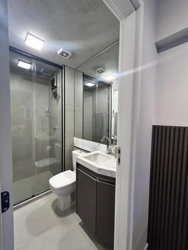 een badkamer met een toilet, een wastafel en een douche bij Studio 905 in Marília