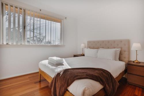 En eller flere senge i et værelse på Restful Canberra Retreat in Spacious Terrace Home